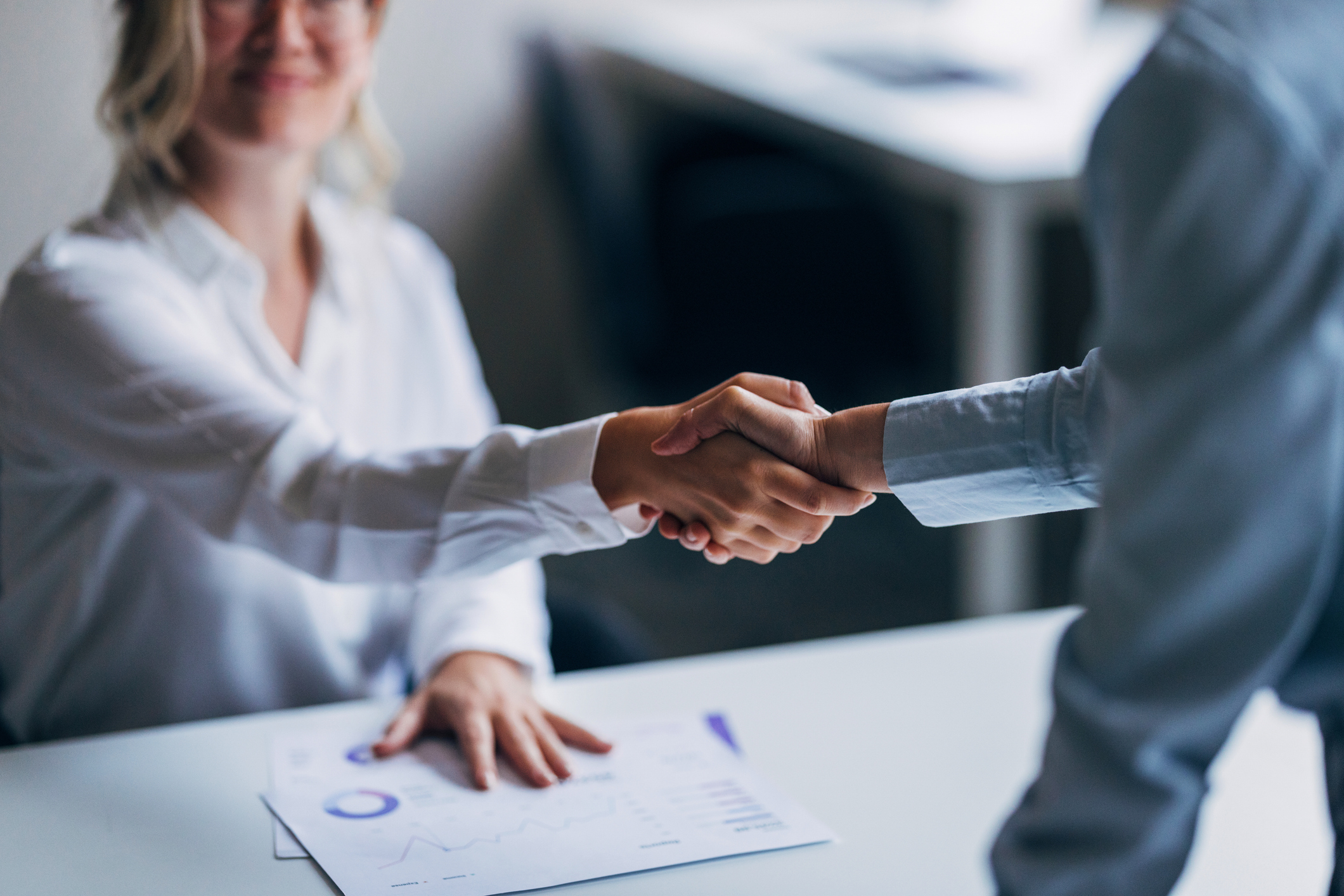 Business Professionals Shaking Hands In A Workplace Setting